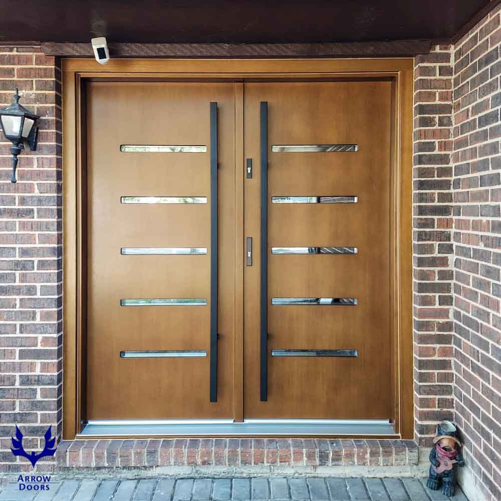 Wood main door in a double door design with metal bar handle, locksets, and a CCTV camera just above the door head