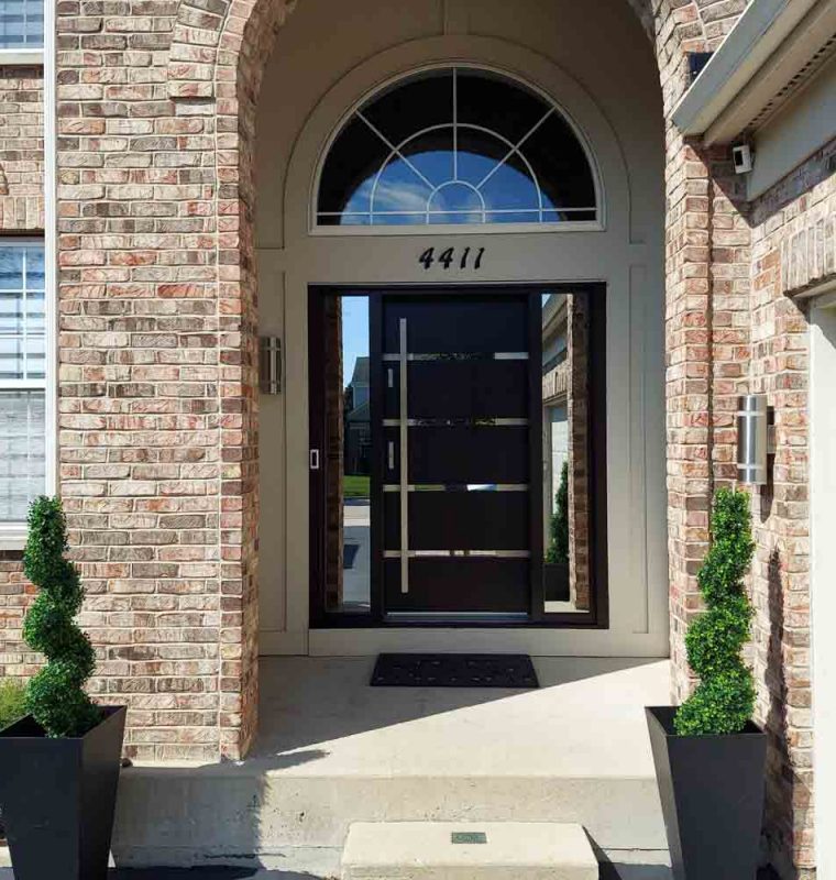 Main door of a house with two sidelights having reflective glass, a bar handle and two locksets