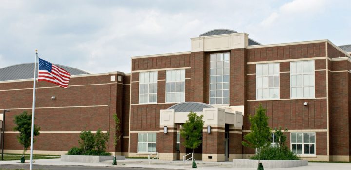 A school with wide glass windows perfect for the concrete establishment, allowing natural light to seep in.