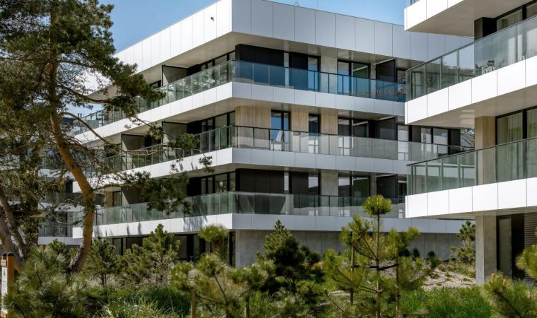 A Hotel with Veranda, protected by metal railings with glass framing walls, glass windows are from ceiling to floor.